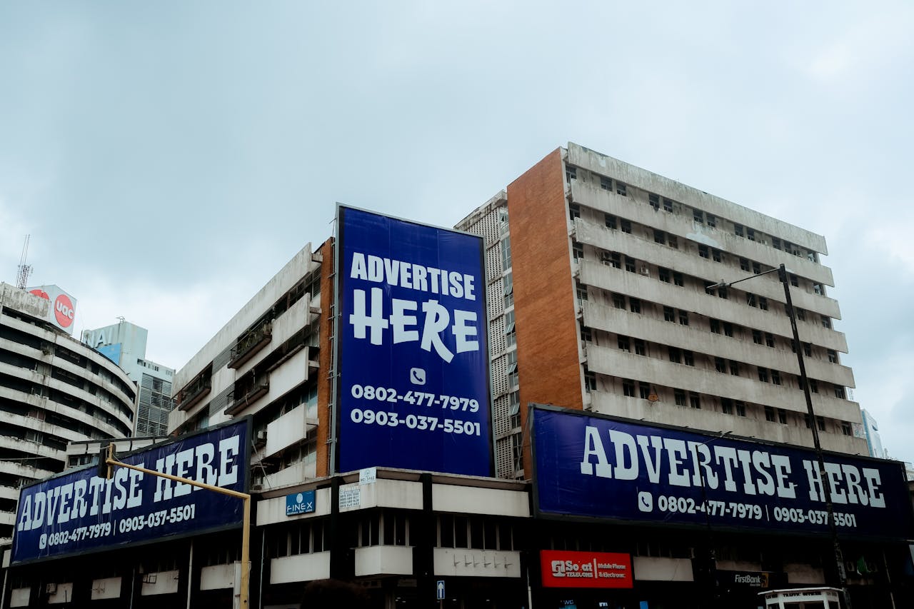 creative Large billboards on urban buildings displaying 'Advertise Here' in Lagos, Nigeria.